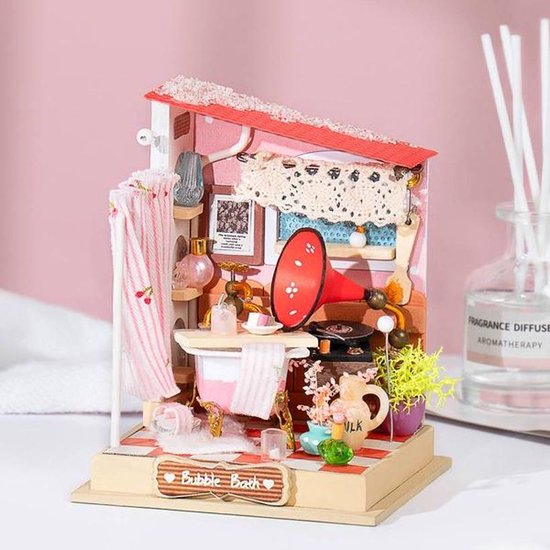 Miniatuur badkamer met rode dak, badkuip, grammofoon, plantjes en een 'Bubble Bath' bordje, met diffuser op achtergrond.