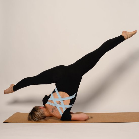 Zwarte jumpsuit met korte mouwen en een kruislings banddetail op de rug, gedragen door een vrouw in een yoga pose op een yogamat.