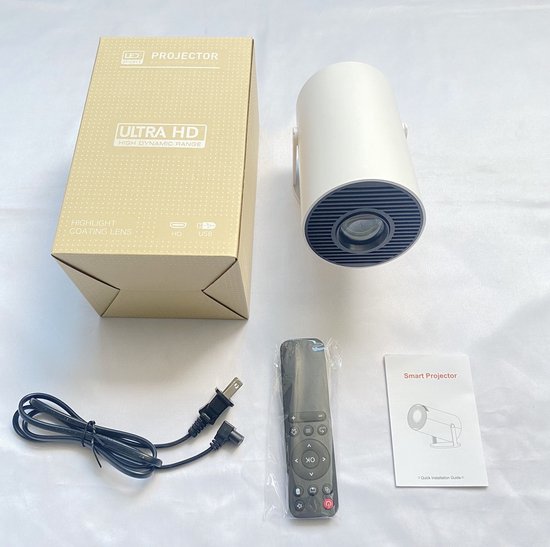 Inhoud van de verpakking: witte mini-beamer, afstandsbediening, stroomkabel, doos en handleiding.