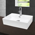 Lavabo rectangulaire en céramique blanche avec robinet chromé et évacuation, sur un plan de travail en bois foncé avec des carreaux gris.