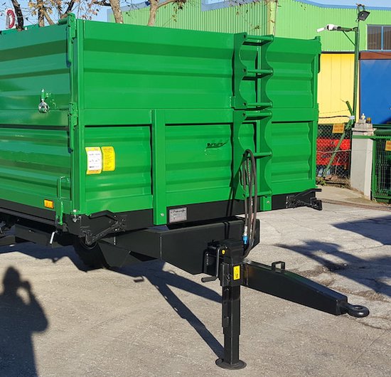 Zwarte steunpoot onder een groene aanhanger, gemonteerd op de trekhaak.