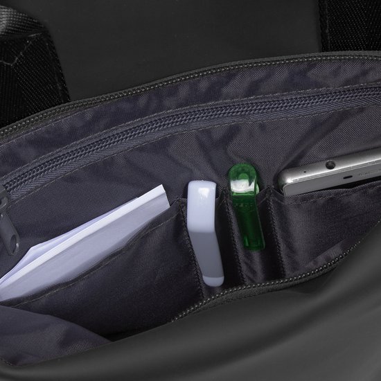 Binnenkant van een zwarte rugzak met open vakken. Een telefoon, documenten, een witte pen en een groene dispenser.