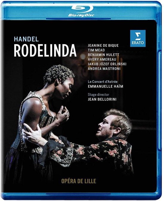 Blu-ray cover: Vrouw met donkere huid in zwarte jurk en man met rossig haar in bloemenjasje kijken elkaar aan.