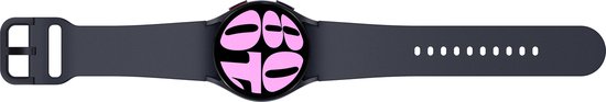 Samsung Galaxy Watch6 in grafietkleur, platliggend, met een zwarte band en een roze wijzerplaat met grote cijfers.