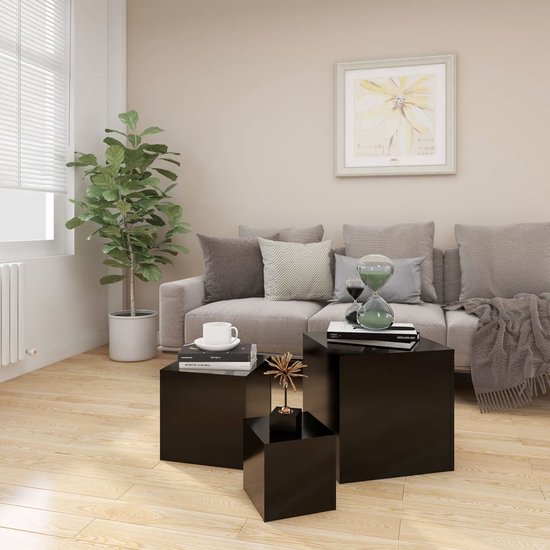 Drie zwarte kubusvormige bijzettafels als salontafels in een woonkamer.