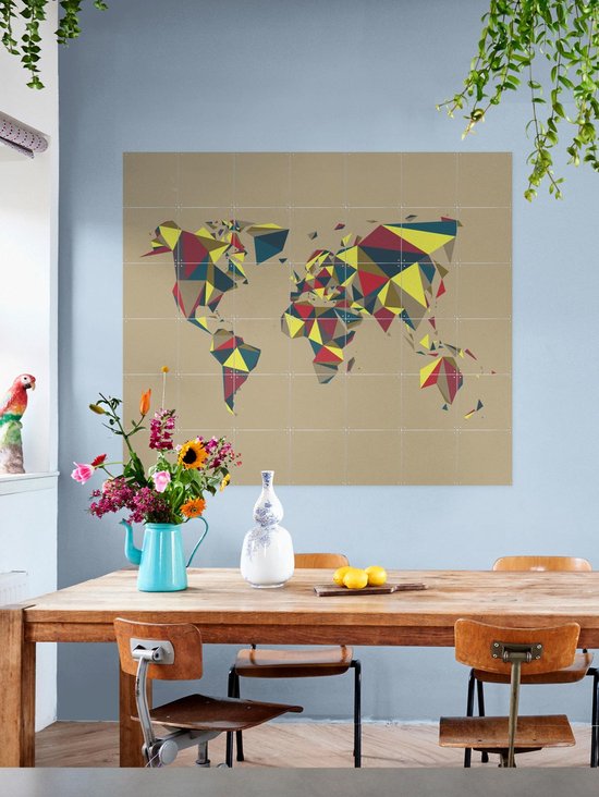 Carte du monde abstraite de style géométrique, suspendue au-dessus d'une table à manger en bois avec des fleurs et des fruits.