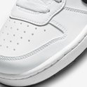 Detail van de neus van een witte Nike sneaker met perforaties en stiksels.