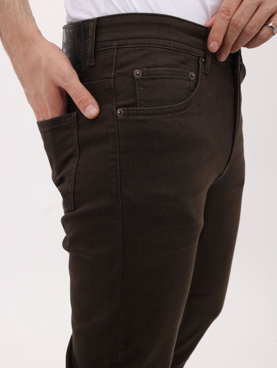 Detail van bruine regular fit jeans, met rechterhand in de zak.