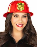 Vrouw met donker haar, draagt een rode brandweerhelm met 'FIRE CHIEF' embleem, en een zwarte jas.