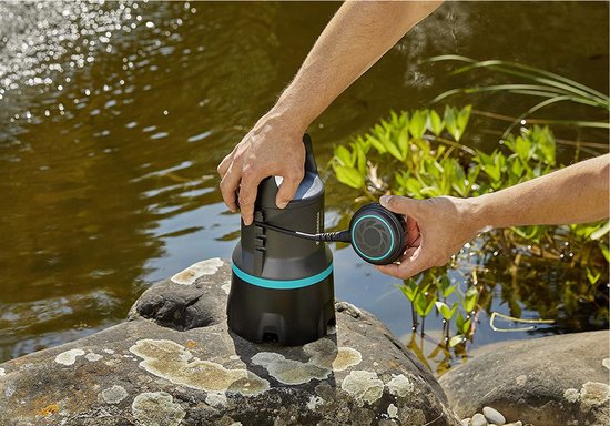 Handen bevestigen een ronde, zwarte filterkop met turquoise ring aan een zwarte dompelpomp.