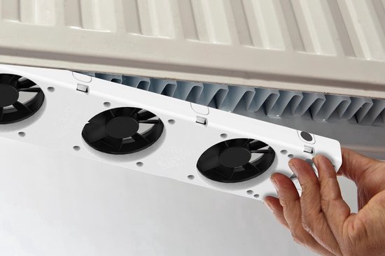 Hand bevestigt witte radiator ventilator set met drie zwarte ventilatoren aan een witte radiator.