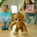 Meisje en vrouw kijken naar een bruine FurReal Peanut aap die loopt.