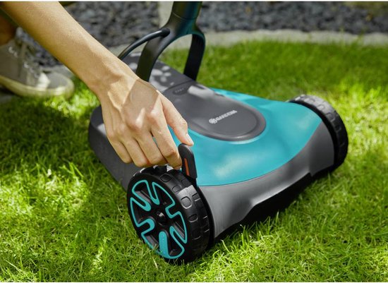 Hand die een oranje hendel op de blauw-grijze grastrimmer beweegt.