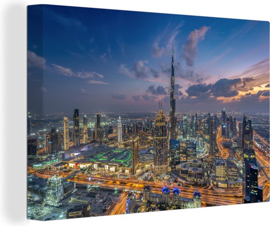 Canvas Schilderij Skyline van Dubai met Burj Khalifa op een bewolkte avond - Wanddecoratie
