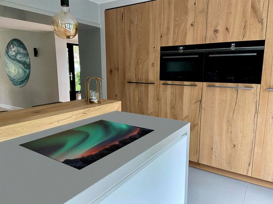 Keukenblad met inductiekookplaat beschermmat met Noorderlicht, geplaatst op een kookeiland.
