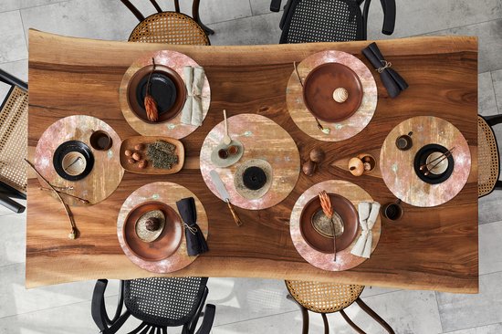 Sets de table ronds avec impression effet rouille en brun et bronze sur une table en bois avec vaisselle.