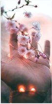 Poster Glanzend – Hand bij Roze Bloemen met Lichtjes - 50x100 cm Foto op Posterpapier met Glanzende Afwerking