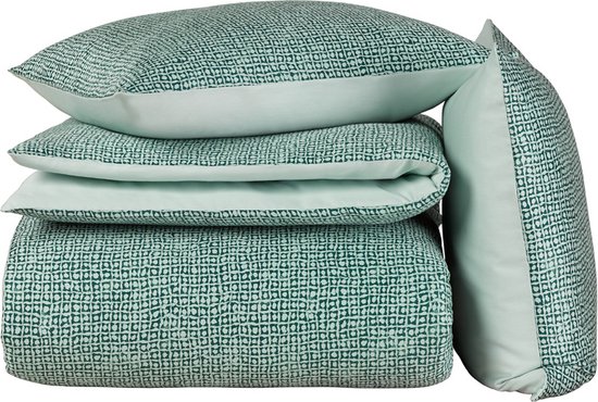 Ensemble empilé de housse de couette et de coussins verts, à motif.