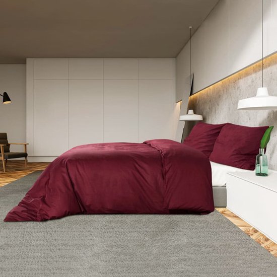 Ensemble de housses de couette bordeaux, drapé sur un lit.