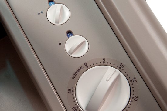 Close-up van de bedieningsknoppen van een zonnehemel, inclusief een analoge timer.