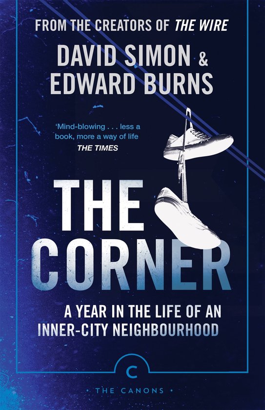 Boek 'The Corner' van David Simon & Edward Burns, met hangende witte sportschoenen, een blauwe rand en de tekst 'THE CORNER A YEAR IN THE LIFE OF AN INNER-CITY NEIGHBOURHOOD'.