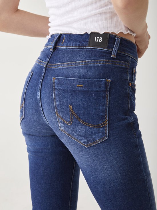 Close-up van de achterkant van een donkerblauwe jeans met gedetailleerde stiksels op de achterzakken en het LTB-logo.