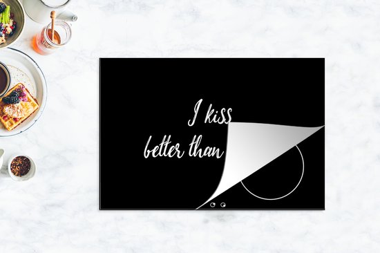 Zwarte kookplaatbeschermer met witte tekst "I kiss better than I cook", met een omgeslagen hoek.