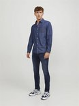 Man in een donkerblauwe denim jeans en een bijpassend spijkerhemd.