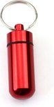 Pilulier rouge étanche avec porte-clés, sur fond blanc.