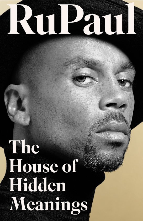 RuPaul in The House of Hidden Meanings, met een zwarte hoed en coltrui.