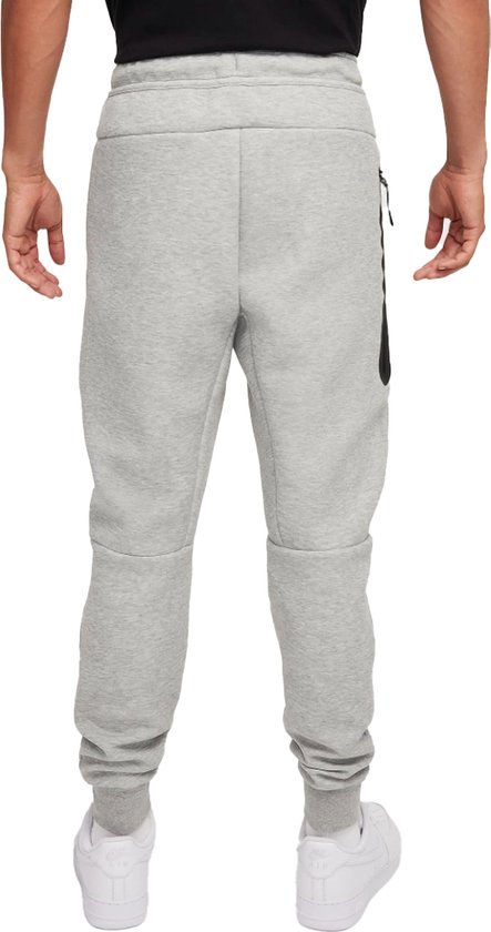 Achterkant van een man in een grijze Nike joggingbroek met zwarte accenten.
