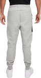 Achterkant van een man in een grijze Nike joggingbroek met zwarte accenten.