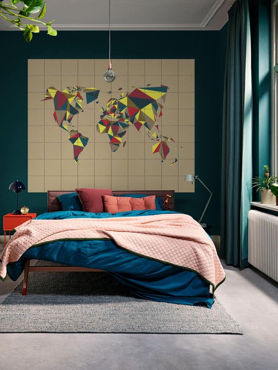 Carte du monde avec des motifs géométriques rouge, jaune et bleu, accrochée au mur au-dessus d'un lit.