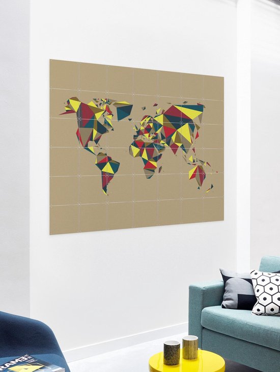 Carte du monde avec des motifs géométriques rouge, jaune et bleu, accrochée au mur dans un salon.