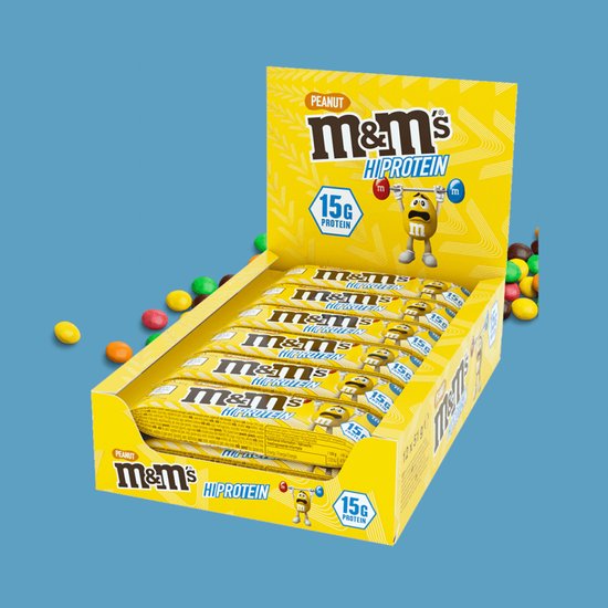 Displaydoos met 12 M&M's Hi Protein Peanut repen in gele verpakking.