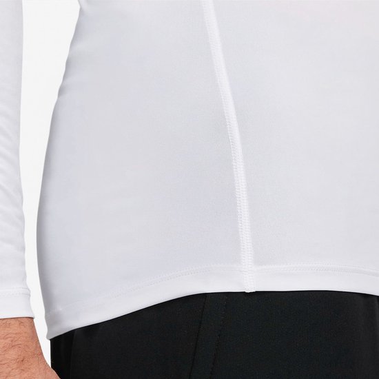 Close-up van de zijkant van een wit Nike Pro longsleeve shirt met stiksels op de taille.