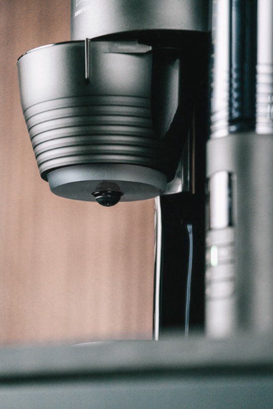 Gedetailleerd zicht op het chromen koffie-uitloopsysteem van een koffiezetapparaat.