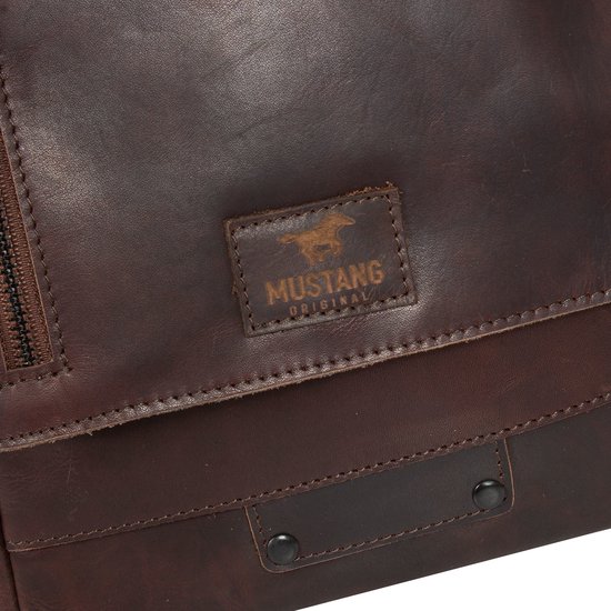 Detail van een donkerbruine leren tas met Mustang logo, rits en drukknoop.