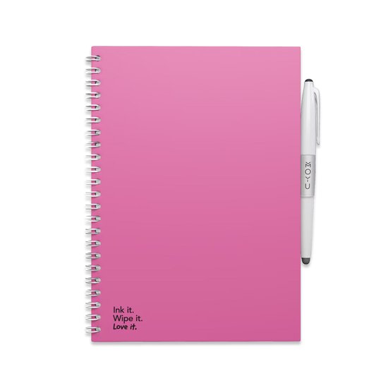 Carnet rose à spirale avec un stylo blanc. Avec le texte 'Ink it. Wipe it. Love it.'