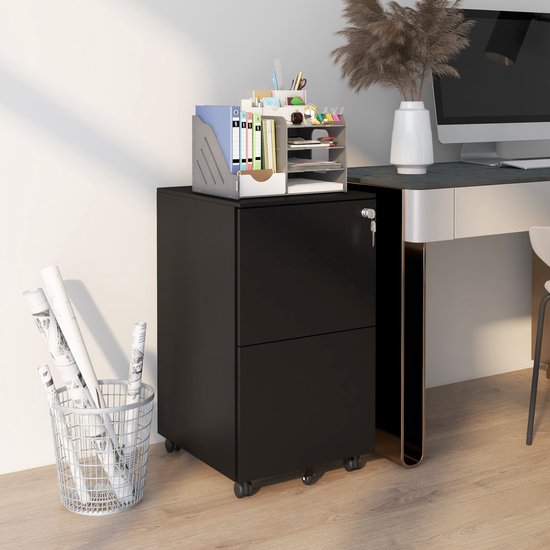 Zwarte, tweelaagse ladekast op wieltjes, naast een bureau met kantoorbenodigdheden.