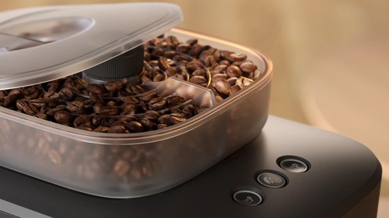 Kop met koffiebonen met een deksel met twee compartimenten.