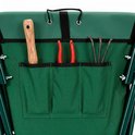 Achterkant van de groene opvouwbare kruiwagen met opbergvak voor tuingereedschap.