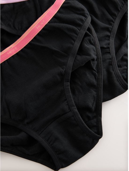Detail van zwarte bikini-onderbroeken met gekleurde taillebandjes met 'NEXT'-logo, waaronder roze en oranje.
