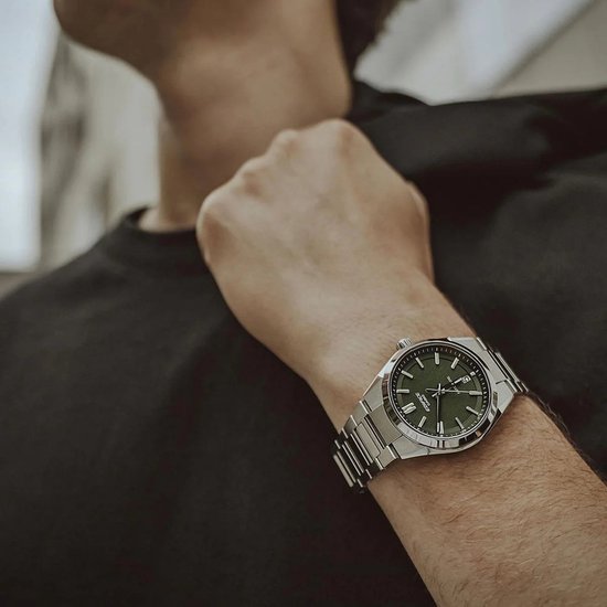 Heren horloge met zilverkleurige metalen band en donkergroene wijzerplaat. Gedragen op een mannelijke pols.