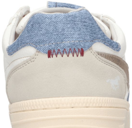 Achterkant van een witte sneaker met blauw denim detail, beige suède en rood zigzagstiksel.