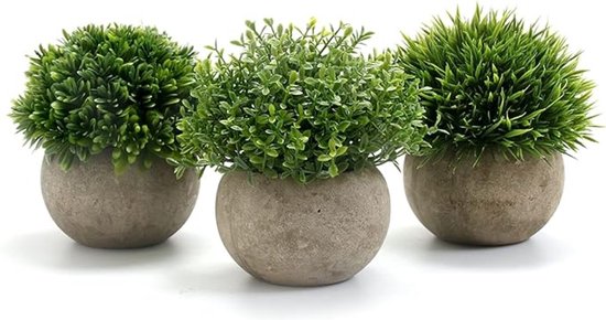 Trois plantes artificielles rondes avec de l'herbe verte dans des pots gris, sur fond blanc.