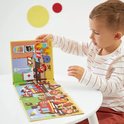 Enfant jouant avec un jeu d'aimants sur le thème des pompiers. Le set comprend des camions de pompiers, une ambulance et des pompiers.