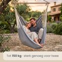 Grijze hangmat voor twee personen, belastbaar tot 150 kg, in een tuin.