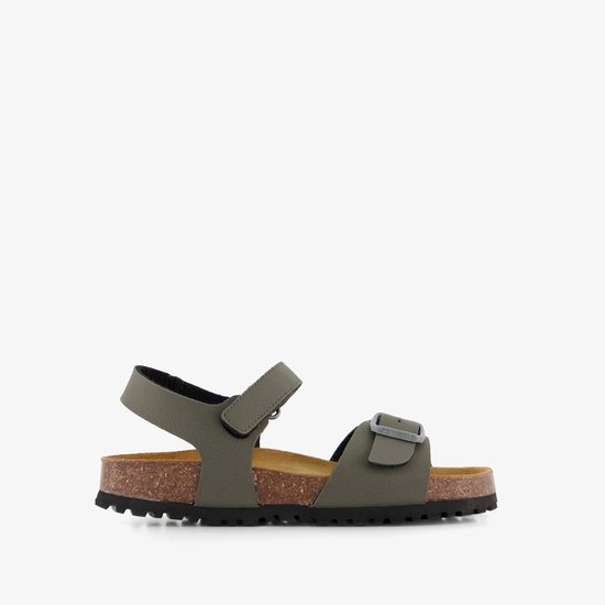 Zijzicht van groene sandalen met kurken zool en gespsluiting.