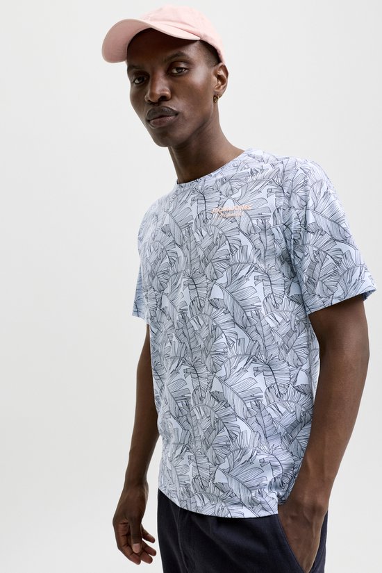 Close-up van man in lichtblauwe T-shirt met bananenbladerenprint en oranje tekst.